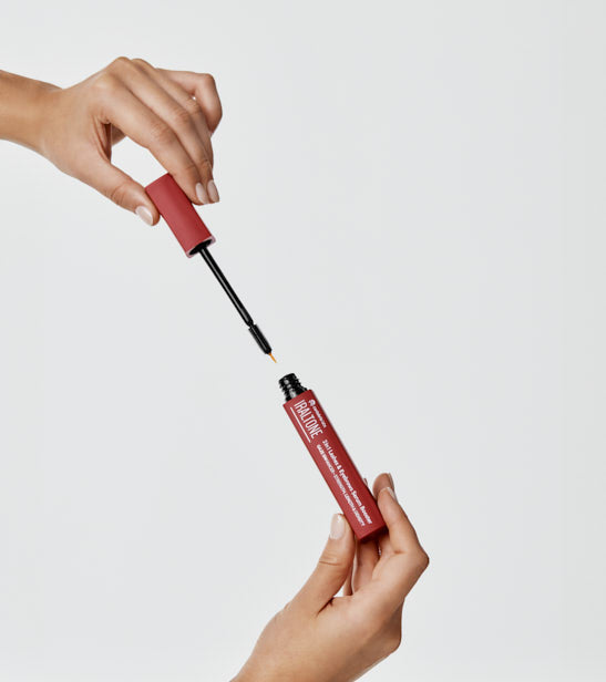 Iraltone Sérum 2 en 1 Pestañas y Cejas 10 ml · aplicador en la mano